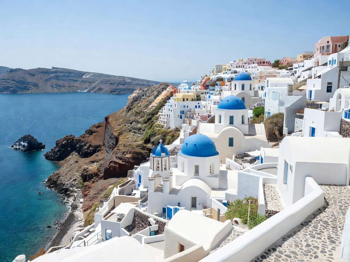 Greek island whitewashed buildings and volcanic basalt overlooking deep blue sea